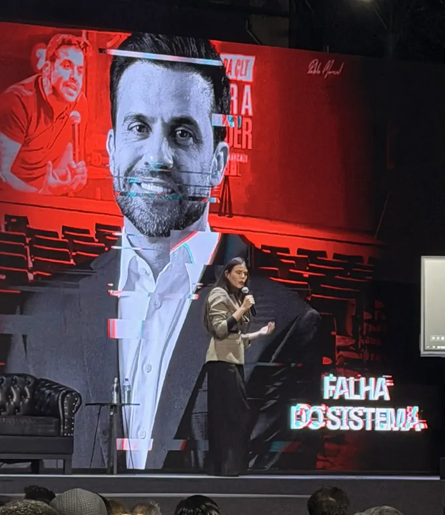 Vanessa Rocha palestrando no palco para uma plateia